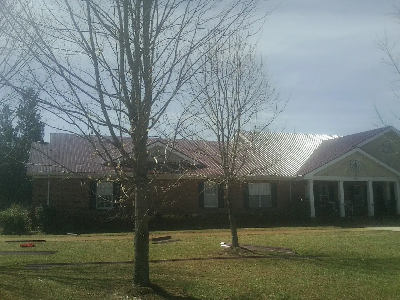Red metal roof on a brick building seen from the front lawn in Shawsville