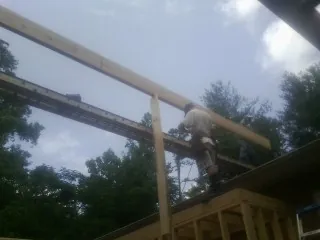 Carpenter setting a ridge beam over a new addition frame — Ice Dam Removal by Roofing Brothers in Shawsville