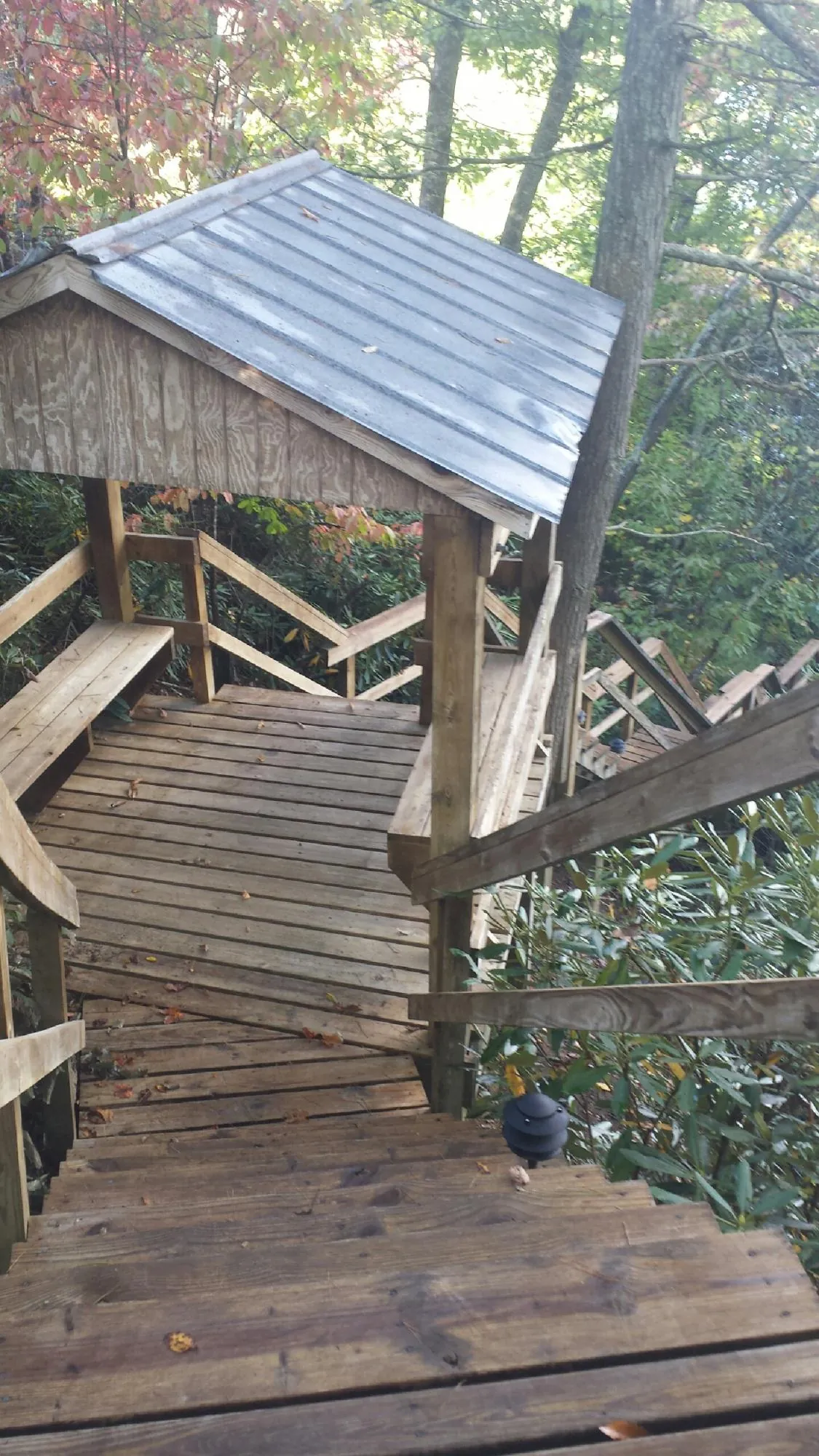 Metal roofed shelter over wooden steps on a wooded walkway — Skylight Repair & Installation work by our crew in Shawsville